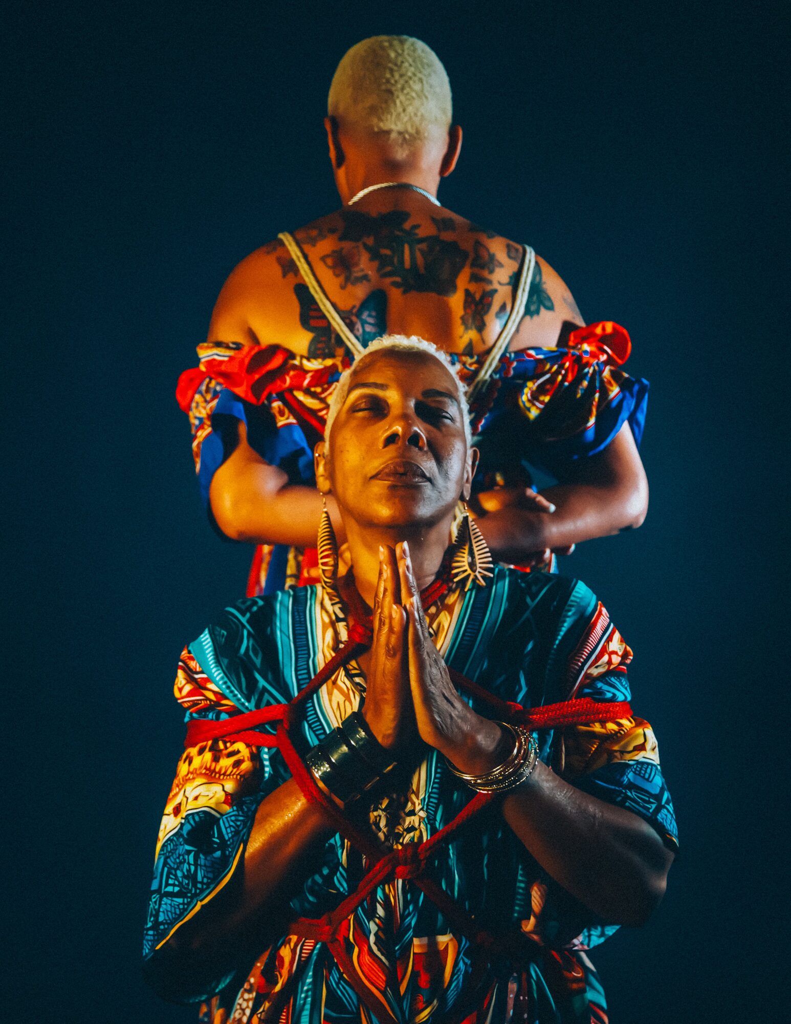 Figure held in rope, light catching the shoulders and clavicle