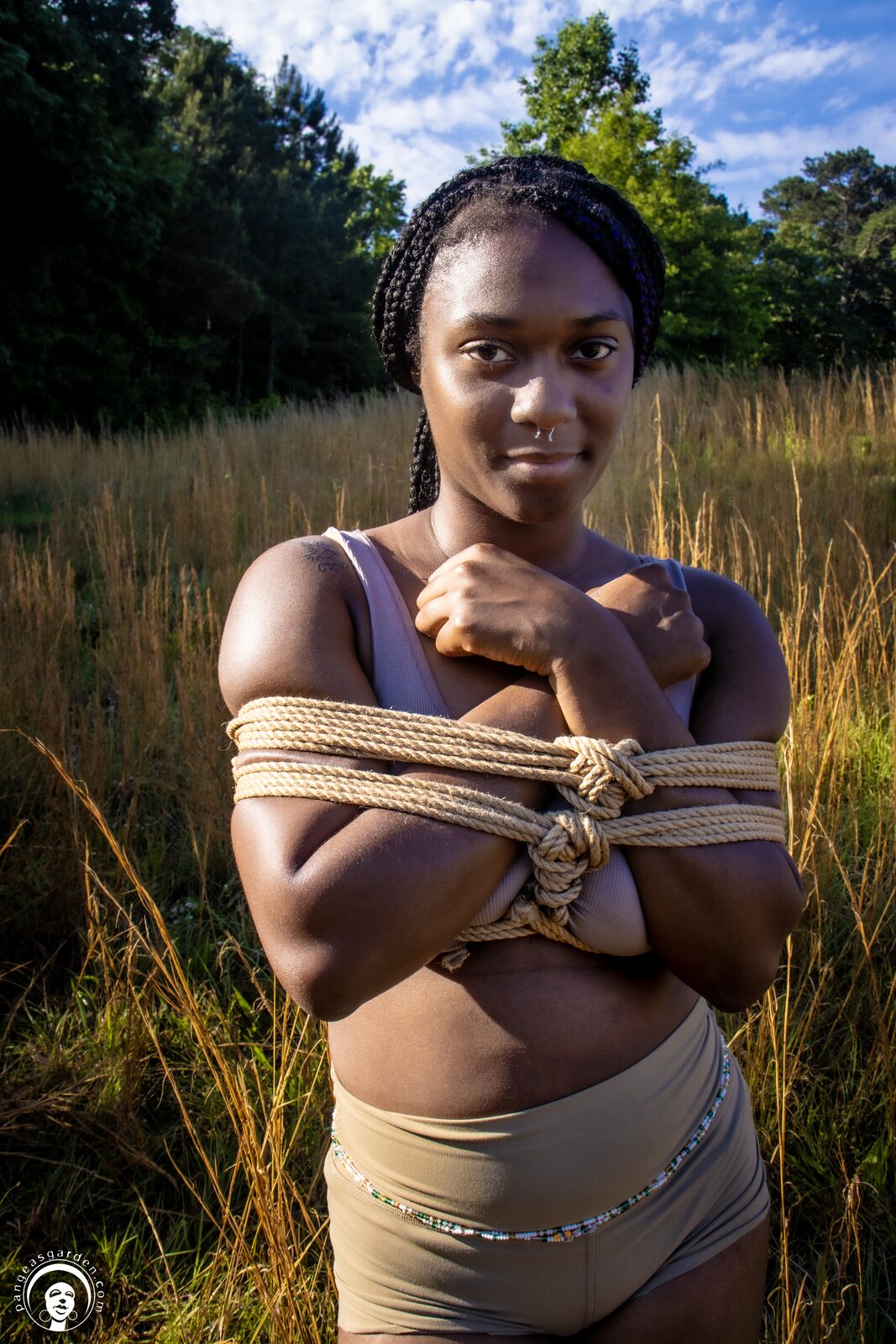 Model standing in tall grass, jute rope crossing the chest.