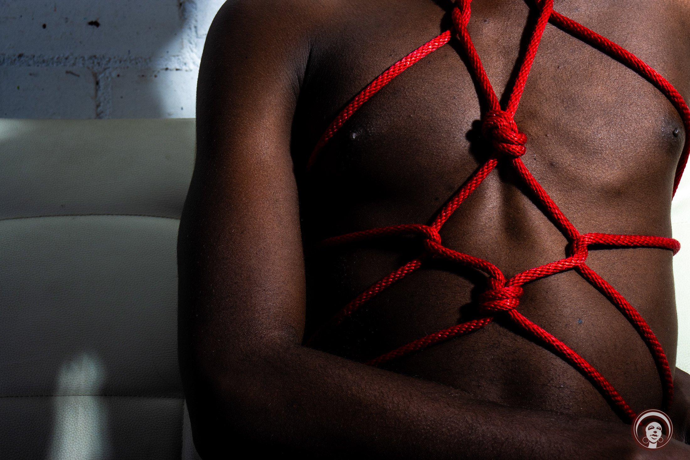 Body in a chest-open tie, the shape opening the breath and changing what is possible inward